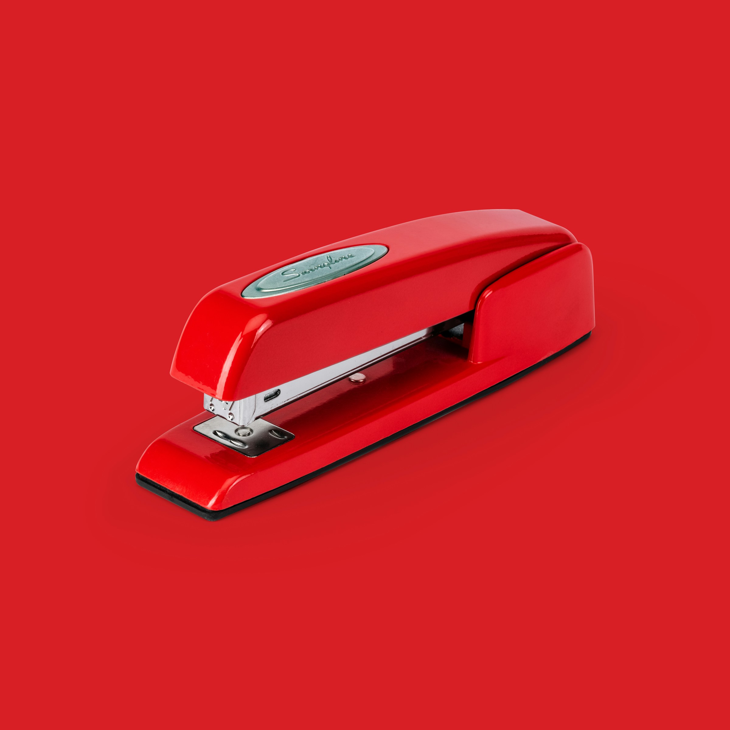 red stapler on red background