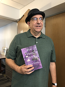 Grant Tracey holding his new book, Five Hard Bites