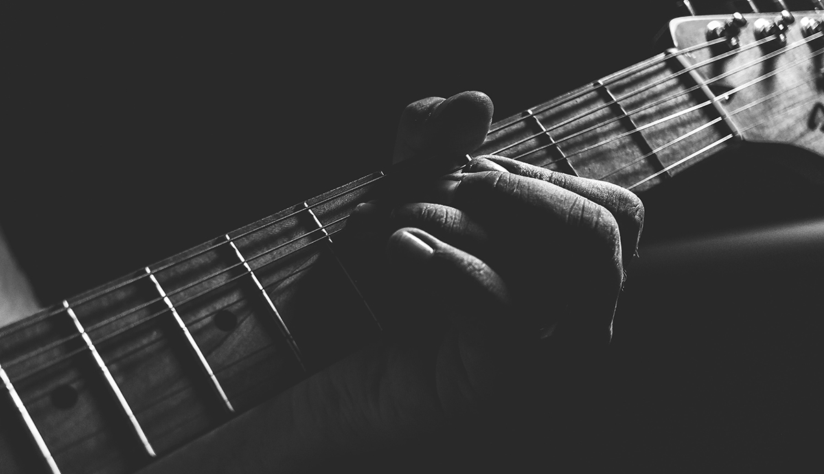 Header Graphic: Grayscale close up on a jazz guitar player | Image Credit: Caio Silva via Unsplash