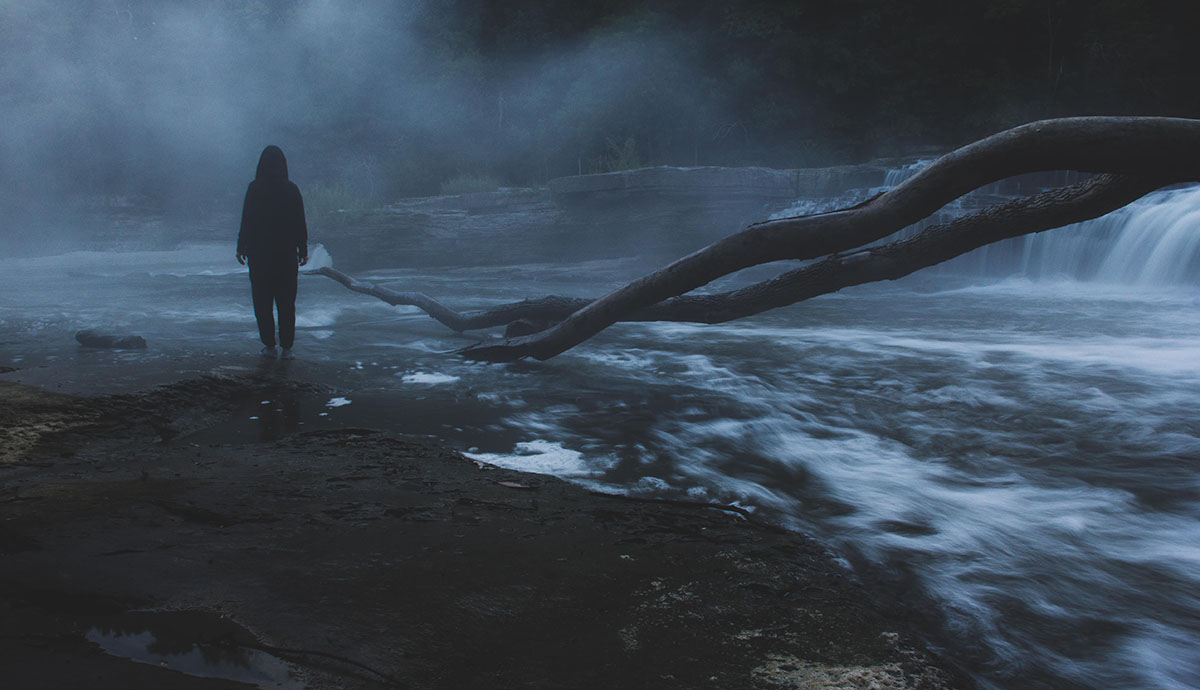 Header Graphic: "Depth" is a photograph of a woman standing in water at night with two branches of a felled tree extending toward the woman like arms of a great leviathan| Image Credit: Cara Spurlock from Flickr