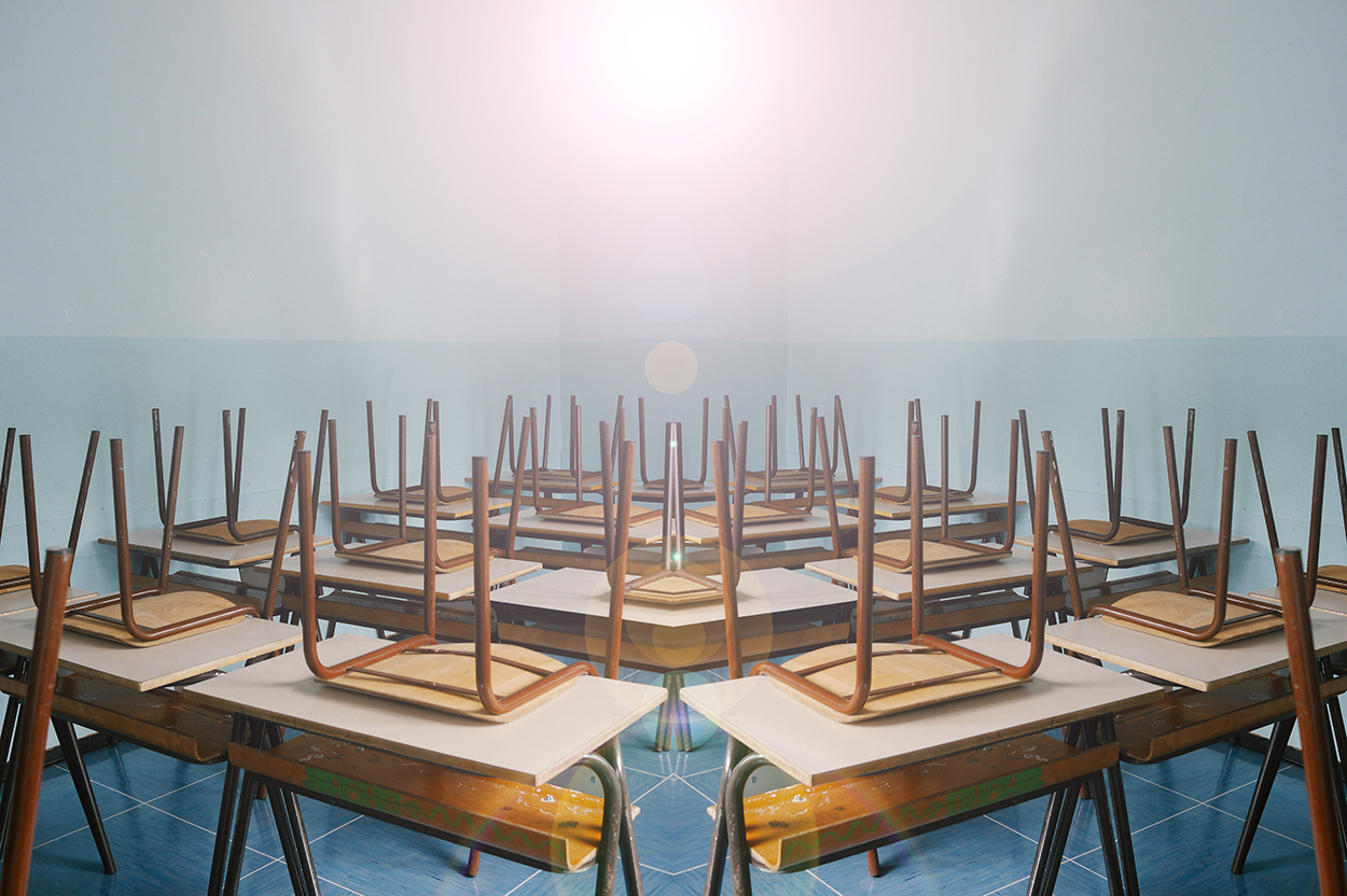 Empty classroom with chairs upside down on desks