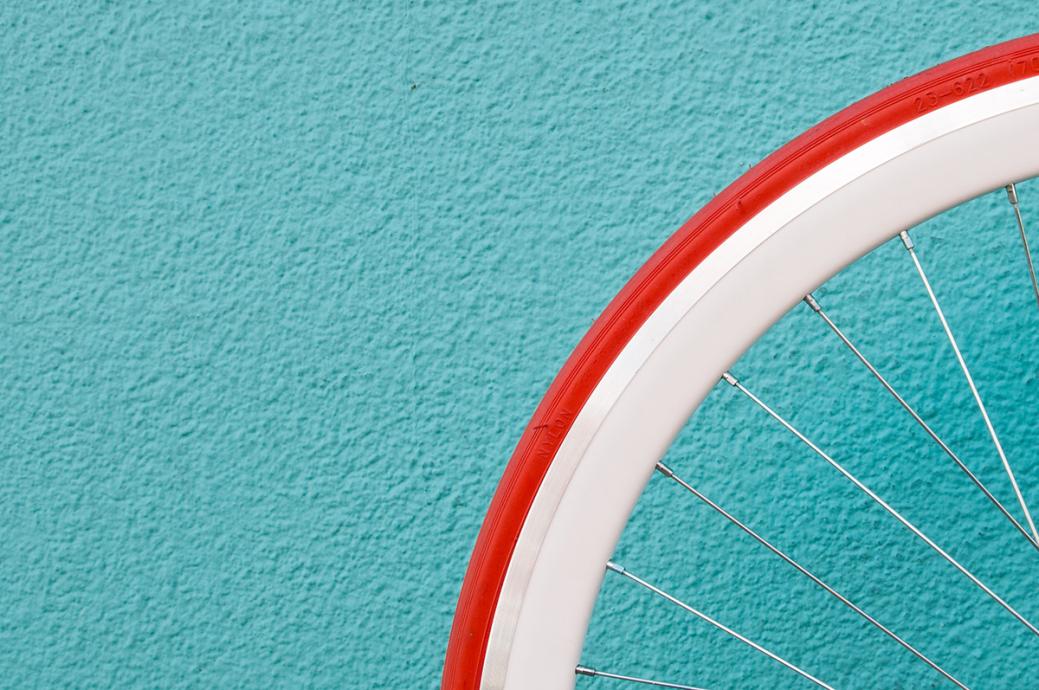 bicycle wheel against blue wall by Alessandra Caretto for Unsplash