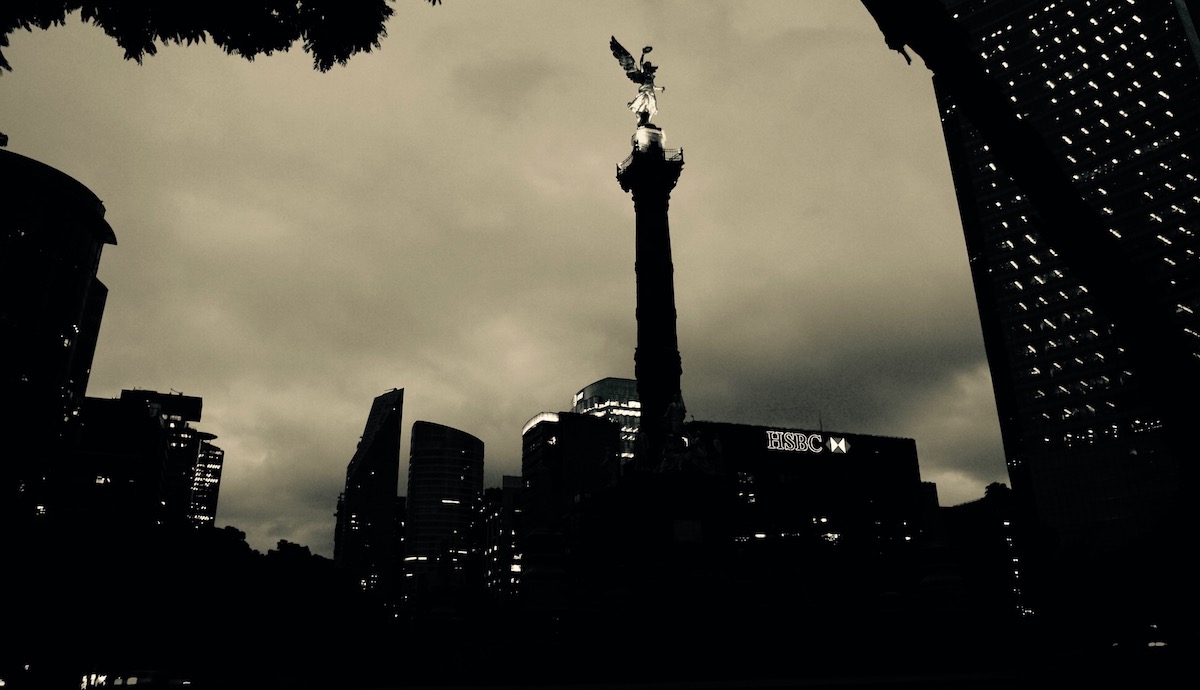 Angel, a photo by Nicolas Poynter. It shows a city and building with an angel sculpture on the tip.