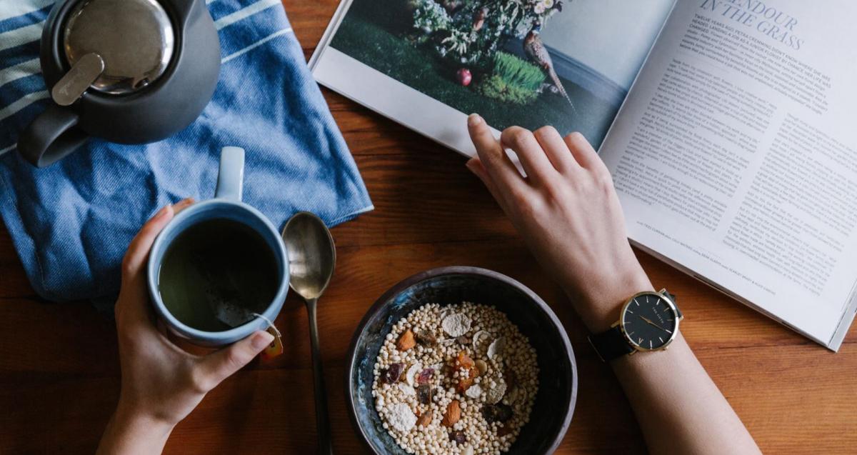 Image of a person eating breakfast and reading