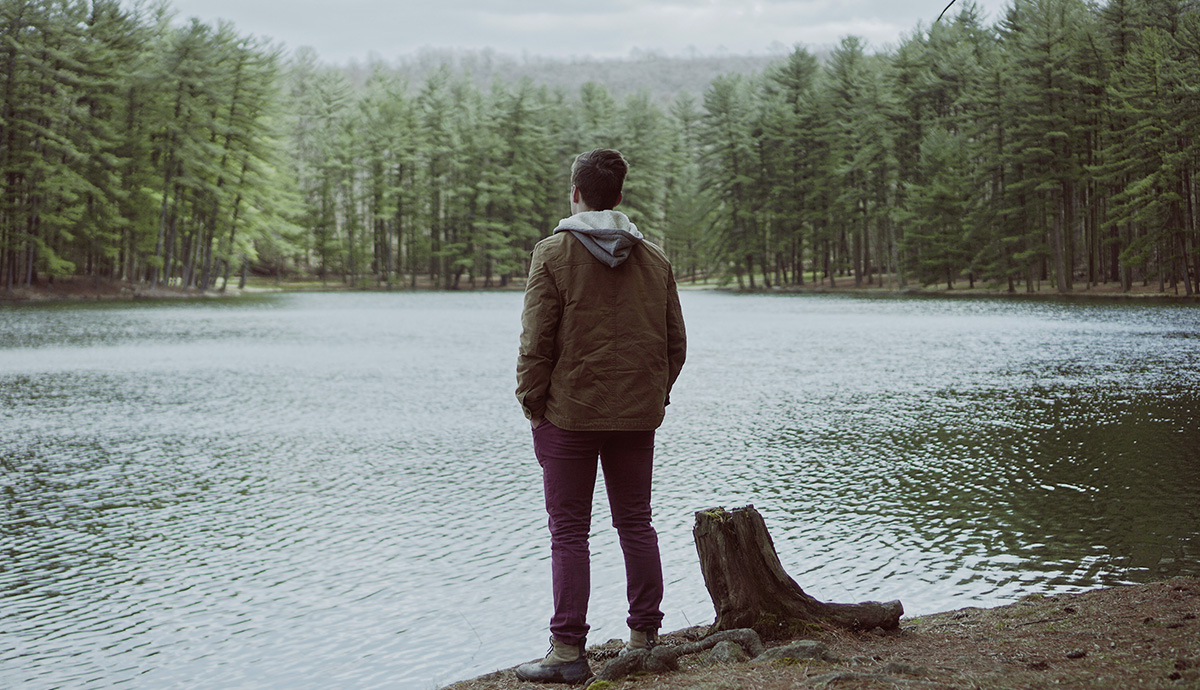 Unsplash Graphic- Man with his back to the camera staring at a body of water 