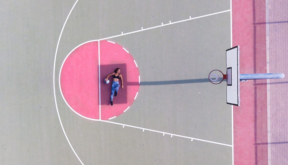 woman laying in basketball court