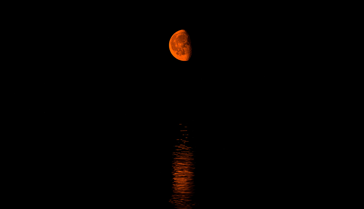 Header Graphic: Red moon reflecting  on water | Image Credit: Marius Niveri via Unsplash