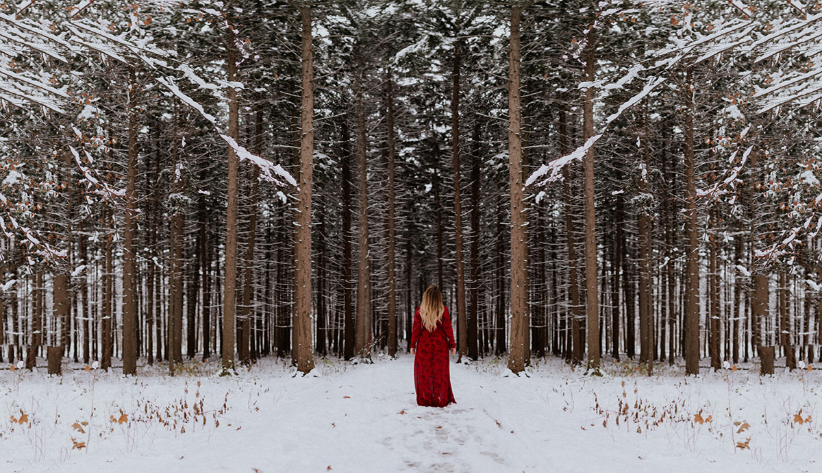 woman standing in front of snowy forest