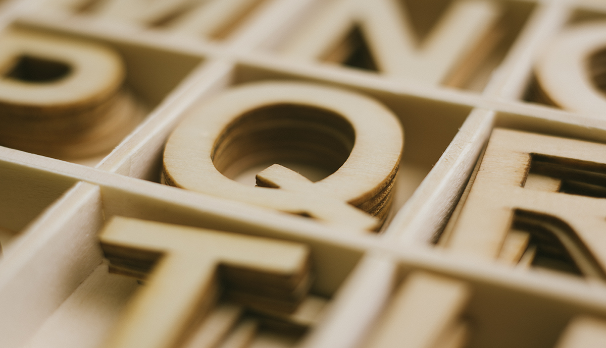 Wooden Q in box of wooden letters