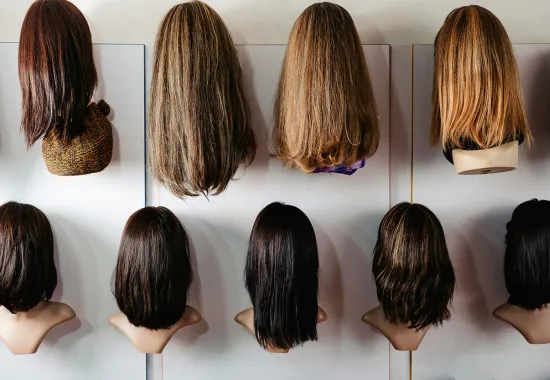 Multiple wigs displayed on a wall 