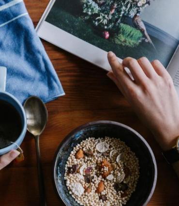 Image of a person eating breakfast and reading