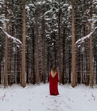 woman standing in front of snowy forest