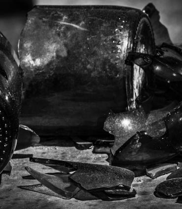 A black and white image of a variety of broken bottles