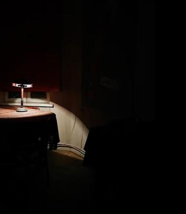 lamp illuminating a table in a very dark room | unsplash