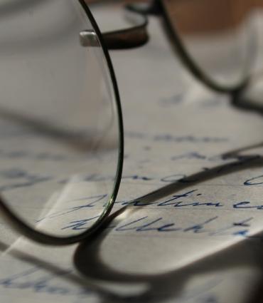 Header Graphic: Spectacles resting atop an open book | Image Credit: Anne Nygard of Unsplash