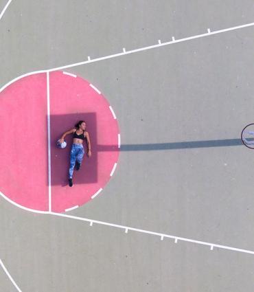 woman laying in basketball court