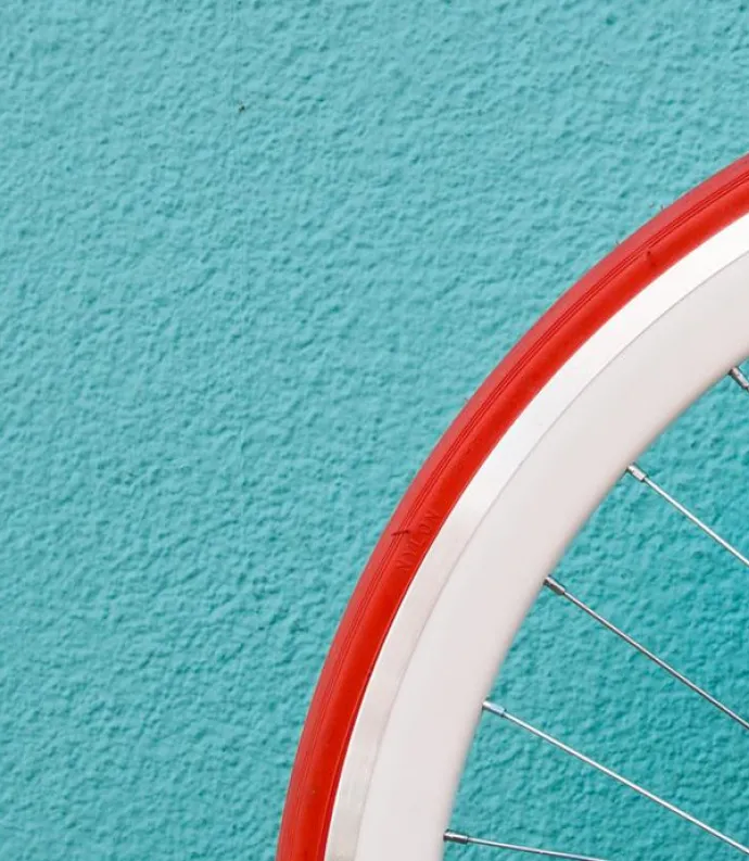 bicycle wheel against blue wall by Alessandra Caretto for Unsplash