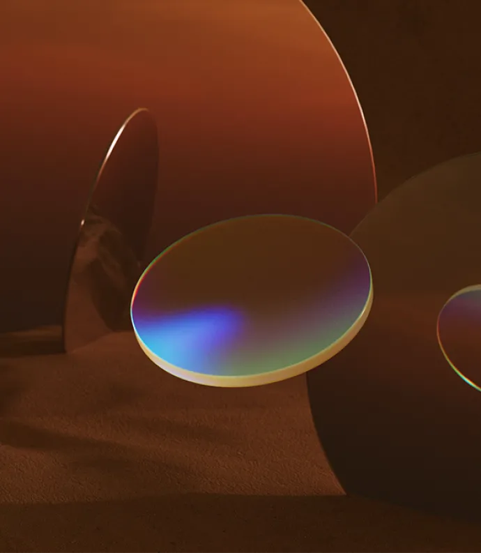 Image of abstract mirror disks nested in sand | unsplash.com/@and_machines