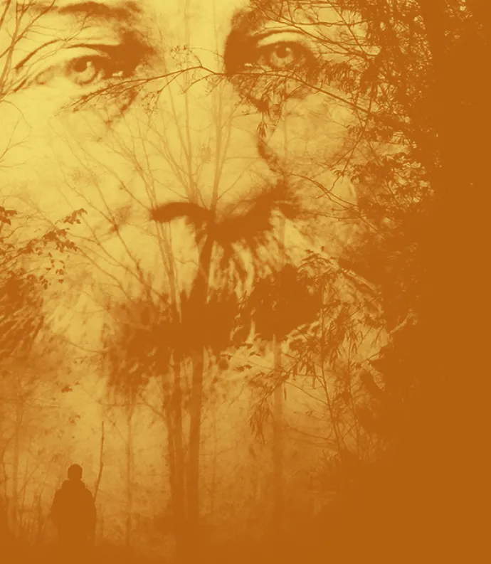 Whitman's face through a treeline