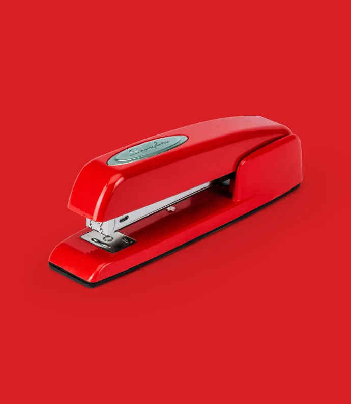 Red stapler on red background