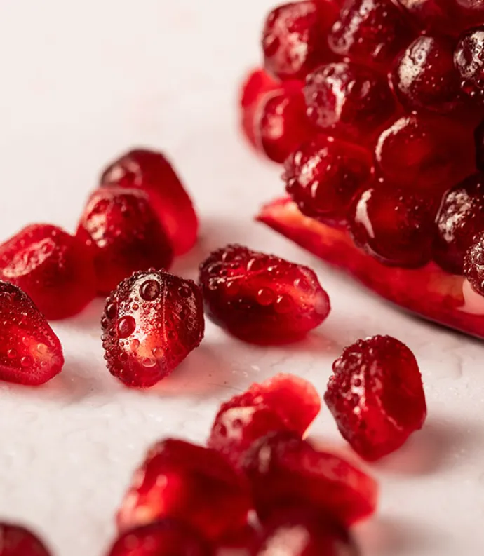 Header Graphic: Pomegranate seeds spilling onto a white background